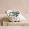 Ocean conch shell jelly wax scented candle on a travertine plinth