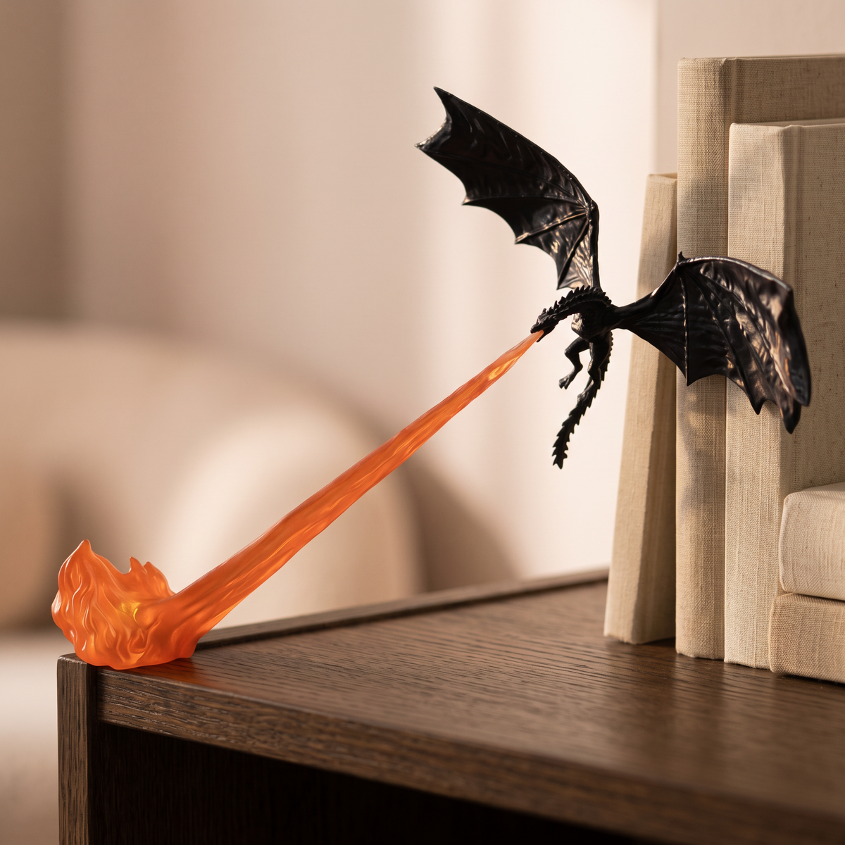 Black dragon with an orange flame trail on a bookshelf